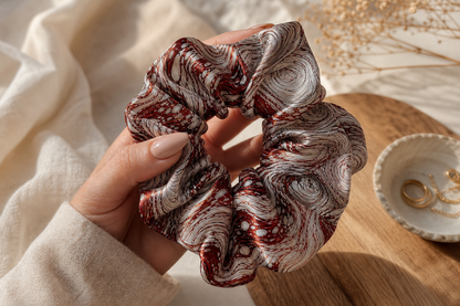 Silver Vortex satin scrunchie held in hand